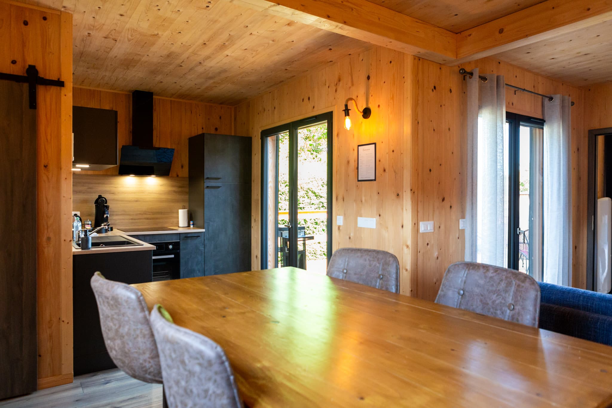 Salle à manger avec table en bois près des baies vitrées