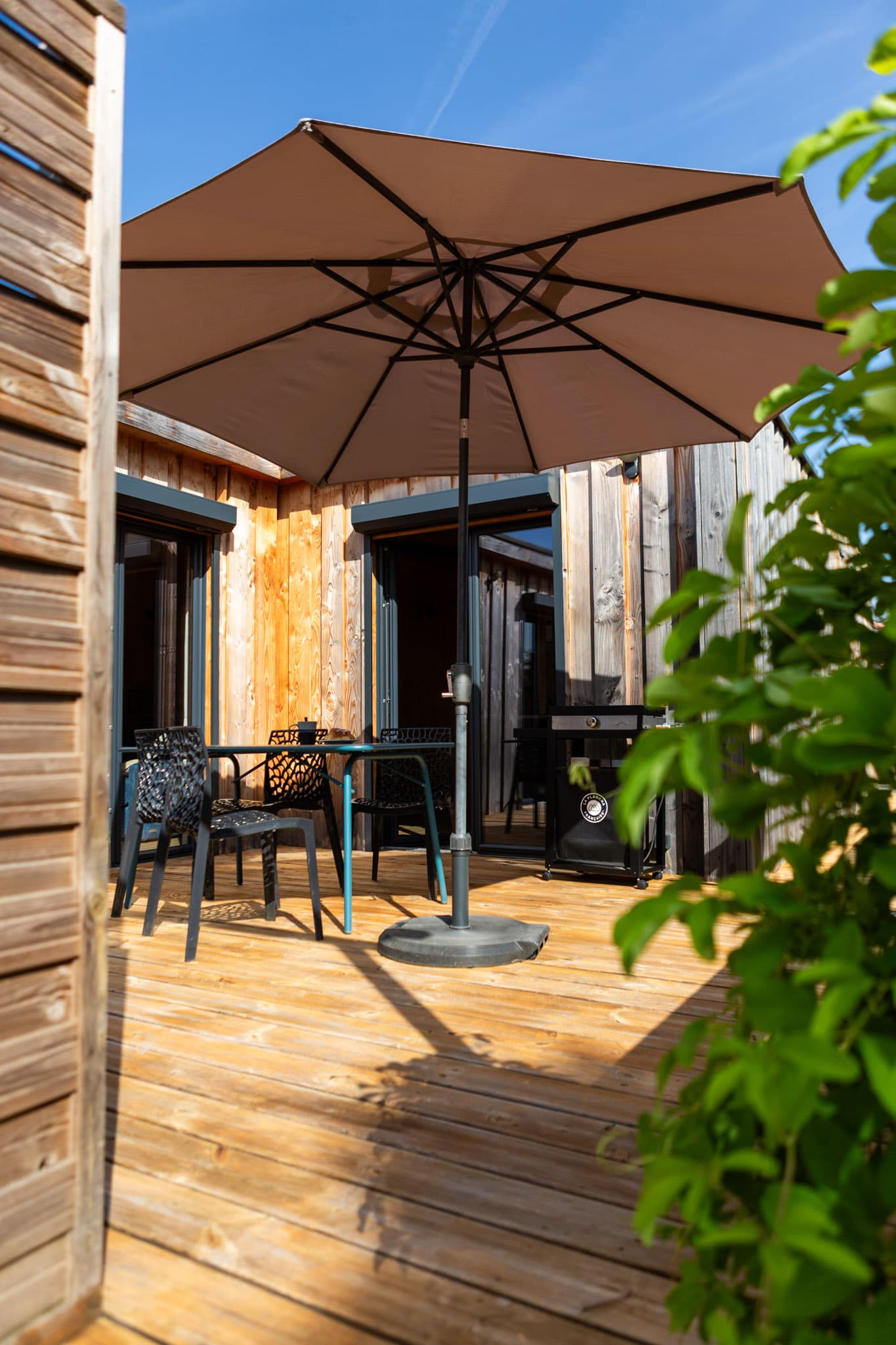 Terrasse privative du gîte La Bridolée avec parasol, prête à accueillir